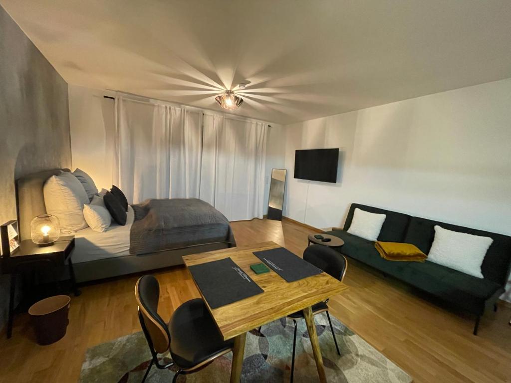 Habitación con cama, mesa y sofá en Studio Stevie Nicks I Parking Spot I Workplace I 24in Screen I Kitchen I PS4, en Offenbach
