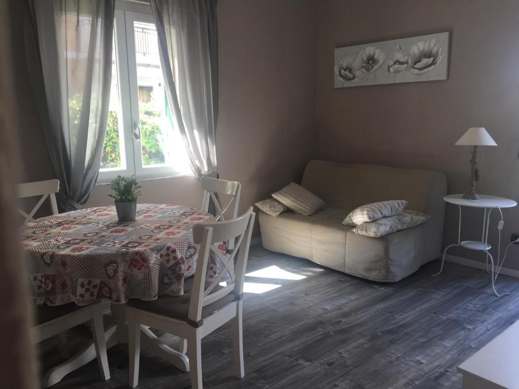Casa vacanze Villetta San Pietro 9 في ديانو مارينا: غرفة معيشة مع طاولة وأريكة