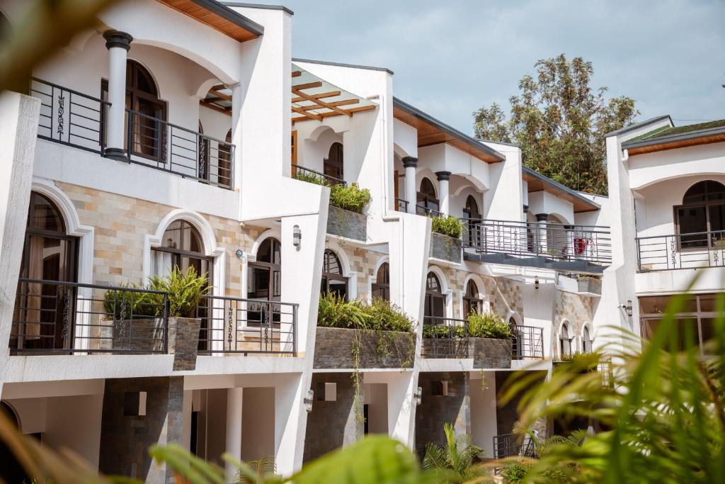 eine Reihe weißer Gebäude mit Pflanzen auf Balkonen in der Unterkunft Ndaru Luxury suites in Kigali