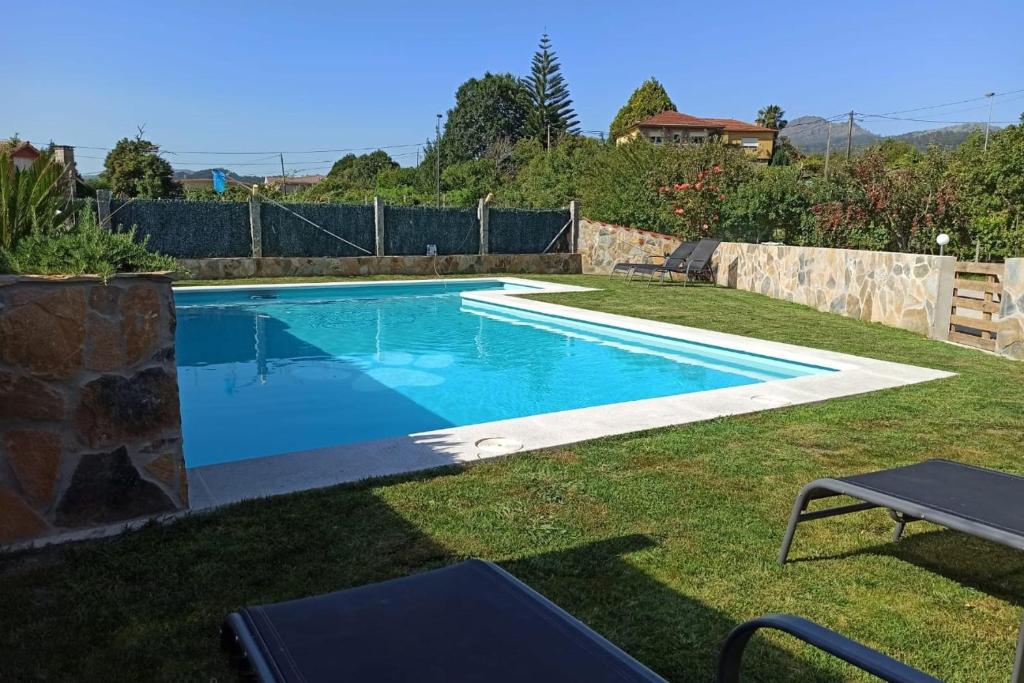 a swimming pool in the yard of a house at AGRADABLE CASA CON PISCINA EN GONDOMAR(VAL MIÑOR) in Pontevedra