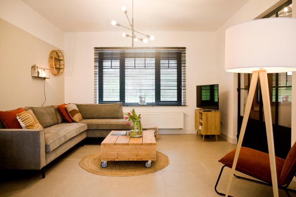 een woonkamer met een bank en een tafel bij Vakantiewoning Spoor 23 in Borgloon