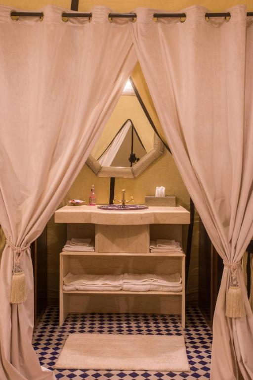 a bathroom with a sink and a mirror at Luxury Desert Camp Amanar in Merzouga