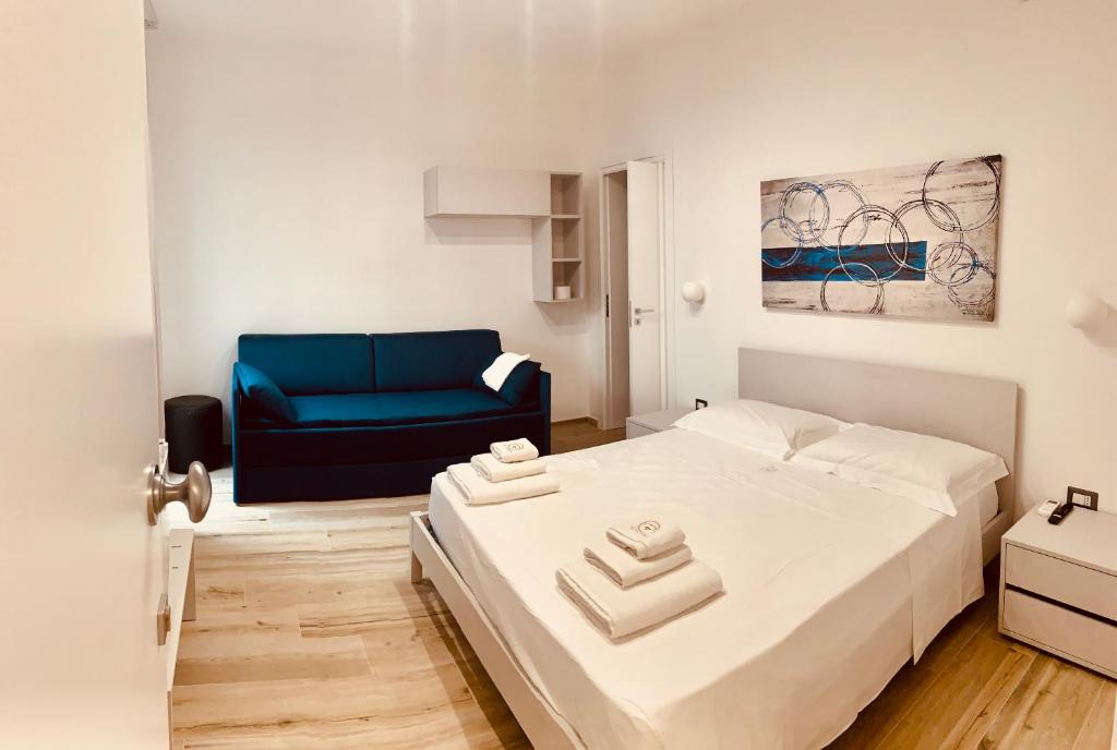 um quarto com uma cama e um sofá azul em Bonaventura em Porto Cesareo
