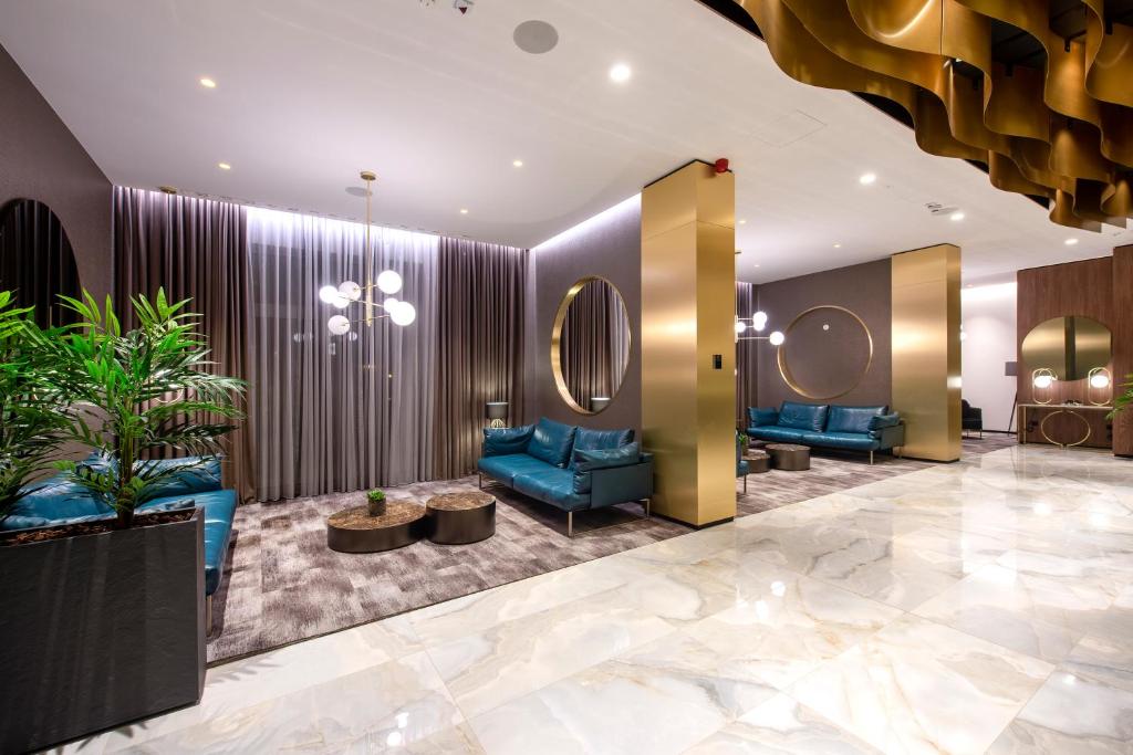 un vestíbulo con sofás azules y espejos en Hotel Turist en Varaždin