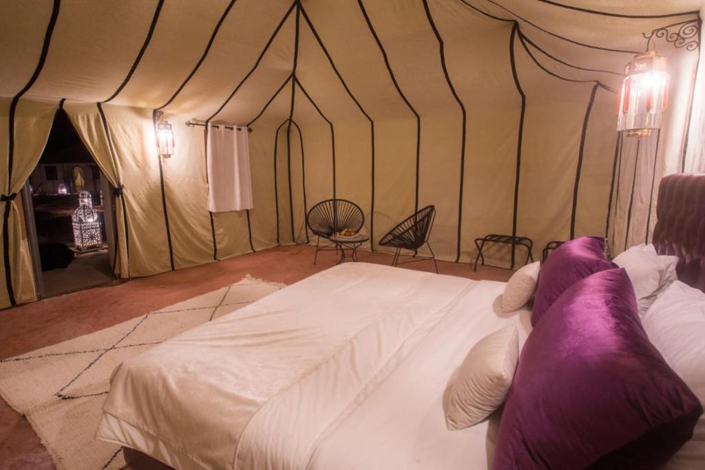 a bedroom with a bed in a tent at Luxury Desert Camp Amanar in Merzouga