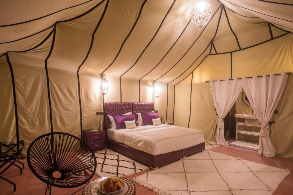 a bedroom with a bed in a tent at Luxury Desert Camp Amanar in Merzouga