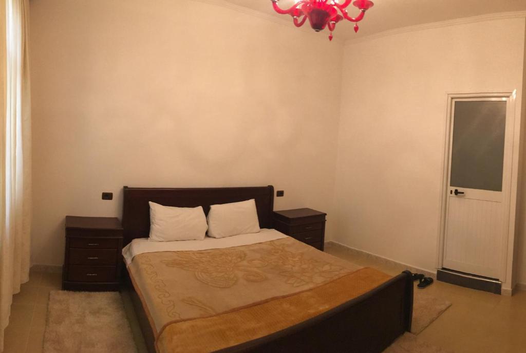 Schlafzimmer mit einem Bett und einem Kronleuchter in der Unterkunft Julton Events Hotel in Domje