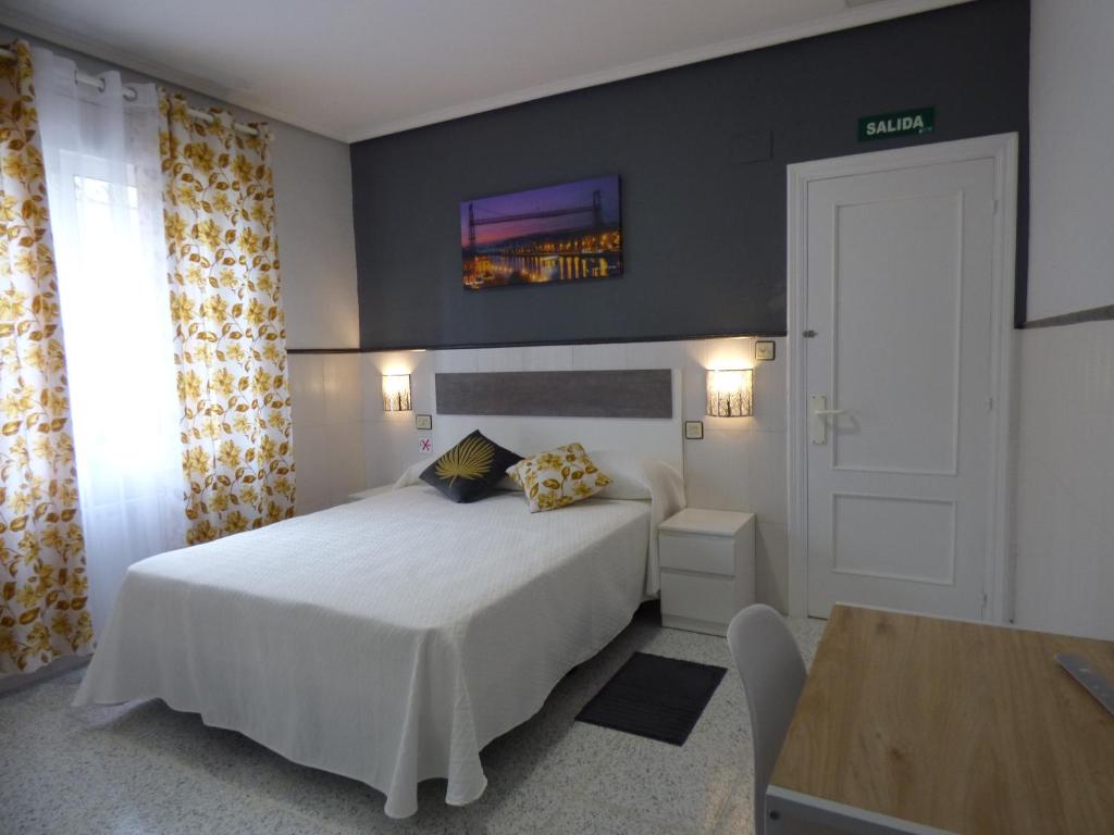 ein Schlafzimmer mit einem Bett und einem TV an der Wand in der Unterkunft Pensión Camino del Norte in Sestao