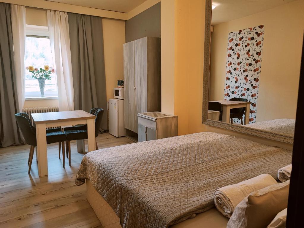 フジェンスコにあるPenzion Přívozのベッド2台、テーブル、鏡が備わる客室です。