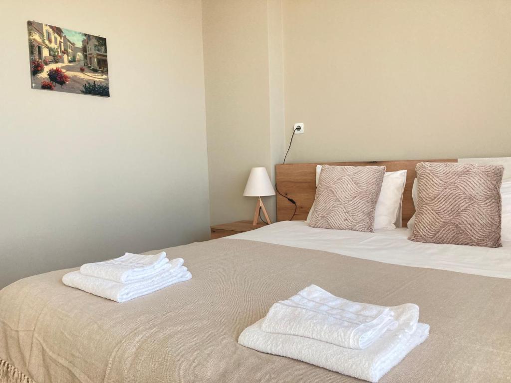 two white towels on a bed in a room at Къща за гости Мегдана in Sopot