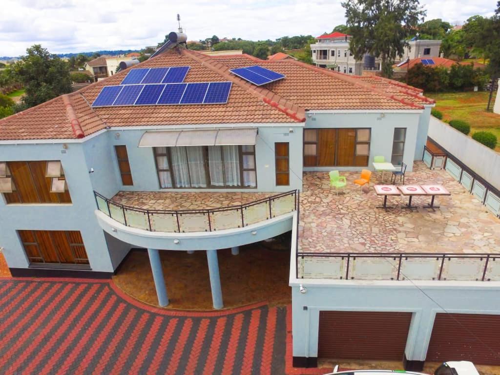 una vista aérea de una casa con paneles solares en el techo en WhiteHouse Lodge en Harare