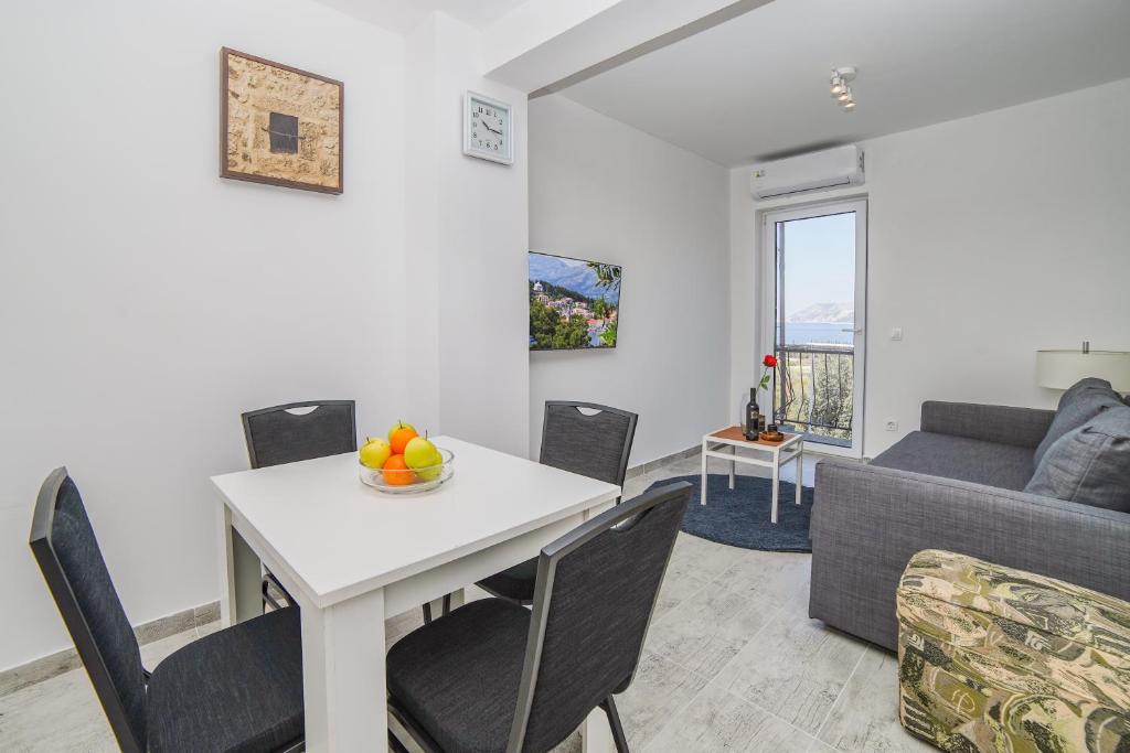 a living room with a table and chairs and a couch at Gustav - Sea view apartment with balcony in Cavtat