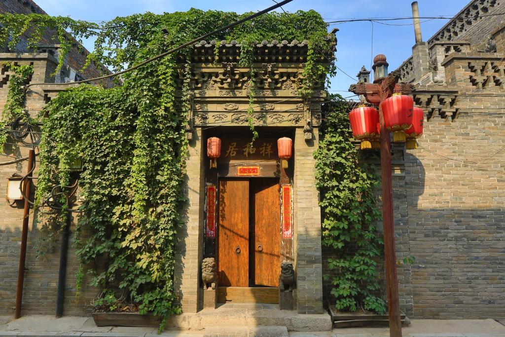 
a red brick building with a red door at Pingyao Laochenggen Inn in Pingyao
