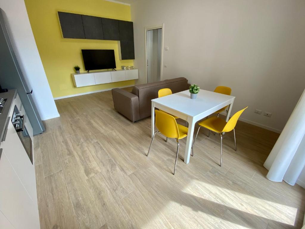 salon z białym stołem i żółtymi krzesłami w obiekcie Eli Home - Royal Welcome w Weronie