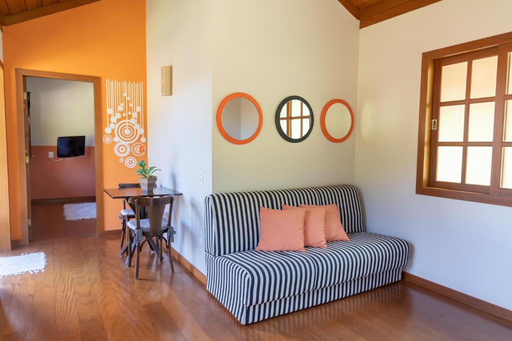 a living room with a striped couch and a table at Pousada Bela Aurora in Venda Nova do Imigrante