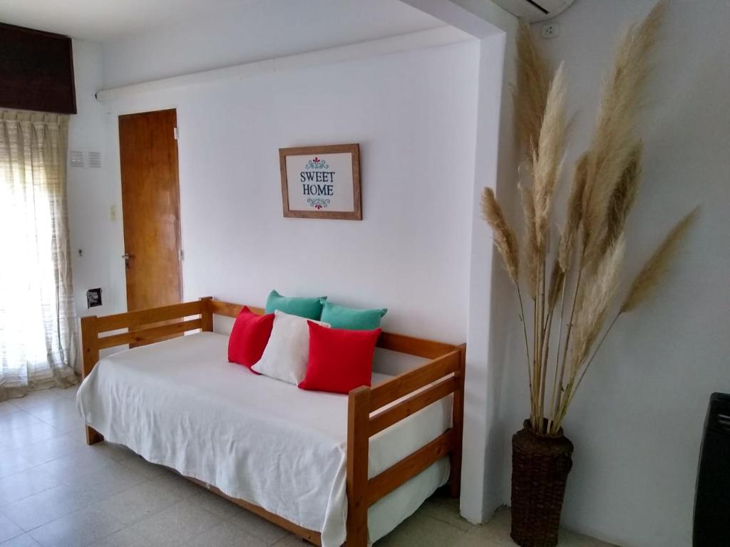 a bedroom with a bed with red and green pillows at Apartamentos Laguna de Navarro in Navarro