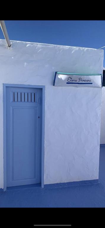 a door in a white room with a sign above it at Eterna Primavera, a 40m de la piscina natural in Punta Mujeres