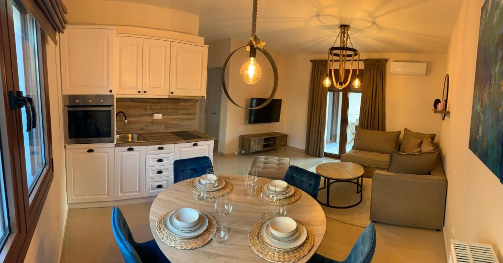 een keuken en een woonkamer met een tafel en stoelen bij Divine Meteora Luxury midtown apartment in Kalabaka