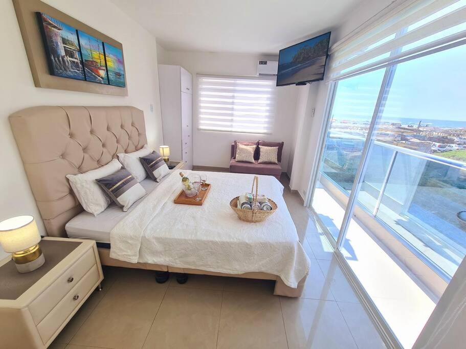 una camera con un grande letto e una grande finestra di Ecusuites Playas Suite 3 Preference Balcón & Jacuzzi Vista al Mar a Playas