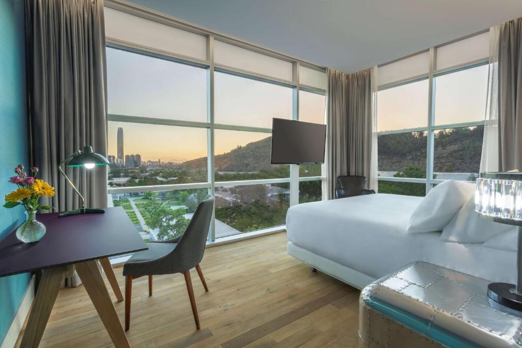 a living room filled with furniture and a window at NH Collection Santiago Casacostanera in Santiago