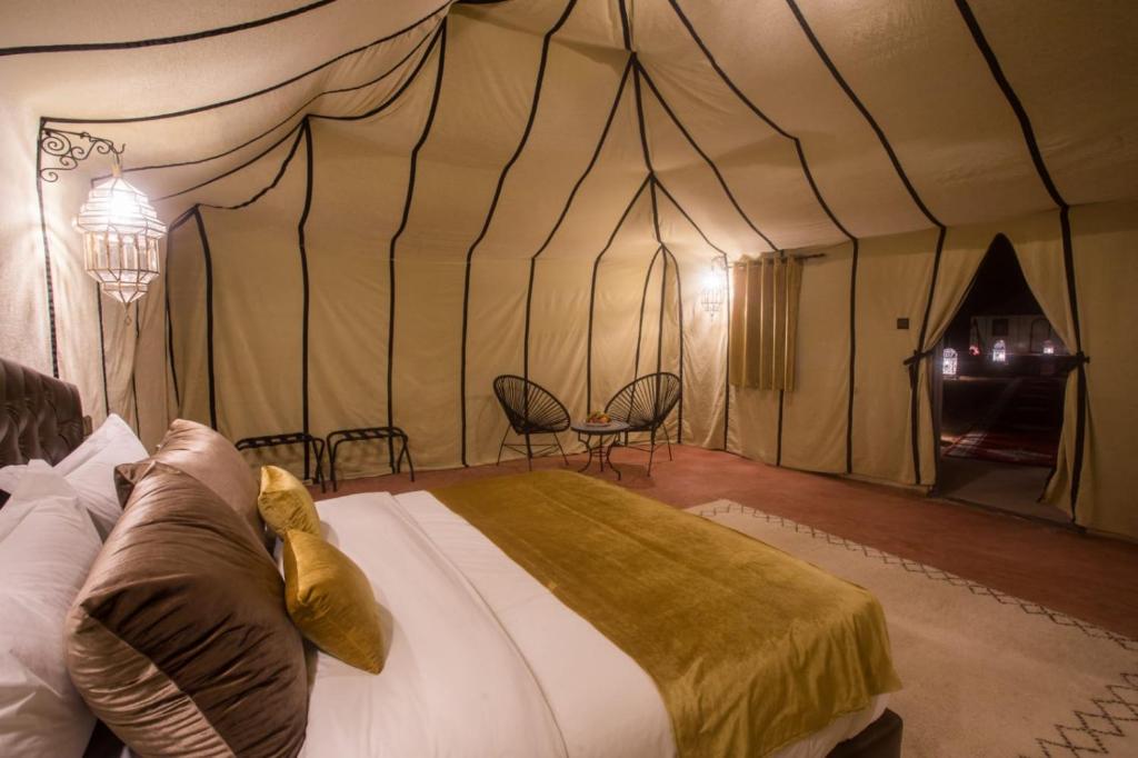 a bedroom with a bed in a tent at Luxury Desert Camp Amanar in Merzouga