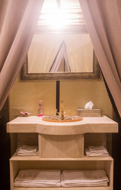 a bathroom sink with a large mirror above it at Luxury Desert Camp Amanar in Merzouga