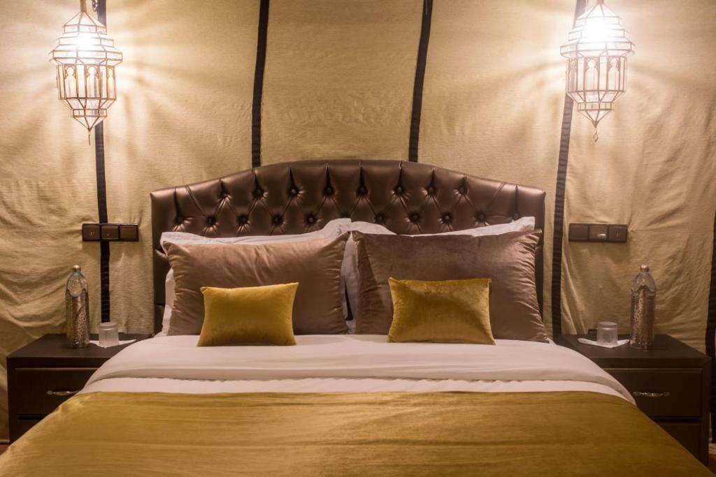 a bedroom with a large bed with two pillows at Luxury Desert Camp Amanar in Merzouga