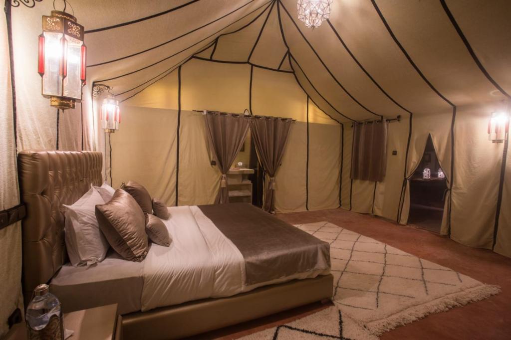 a bedroom with a bed in a tent at Luxury Desert Camp Amanar in Merzouga