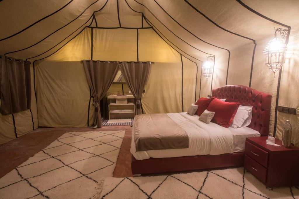 a bedroom with a bed in a tent at Luxury Desert Camp Amanar in Merzouga