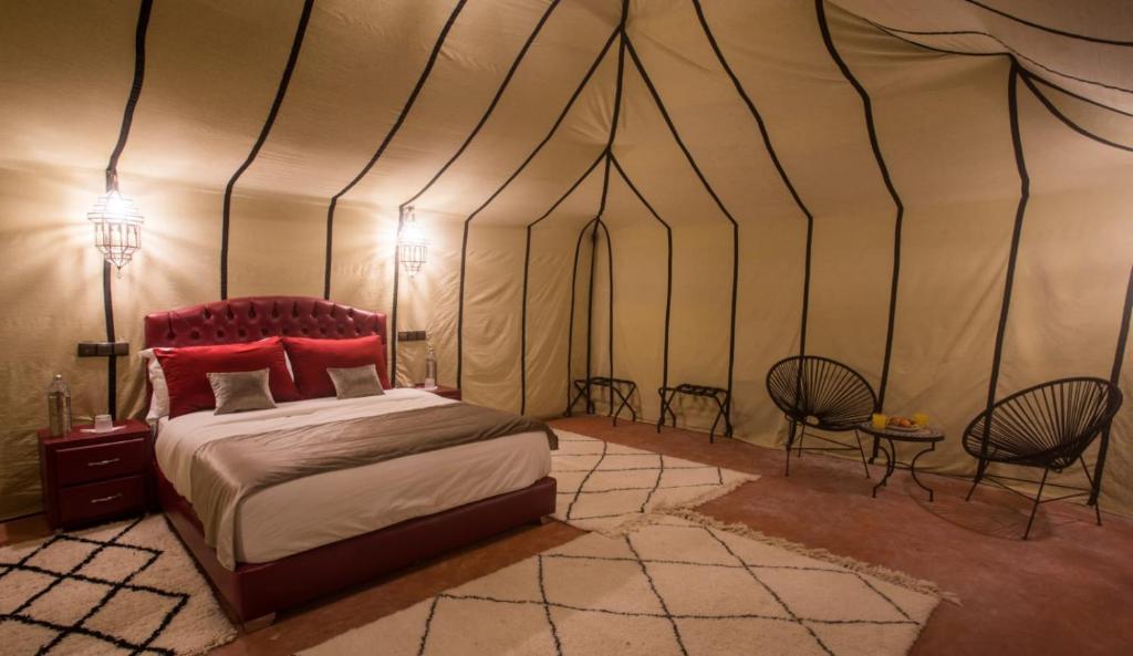 a bedroom with a bed in a tent at Luxury Desert Camp Amanar in Merzouga