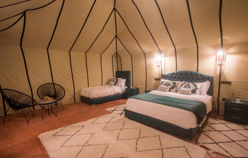 a bedroom with two beds in a tent at Luxury Desert Camp Amanar in Merzouga
