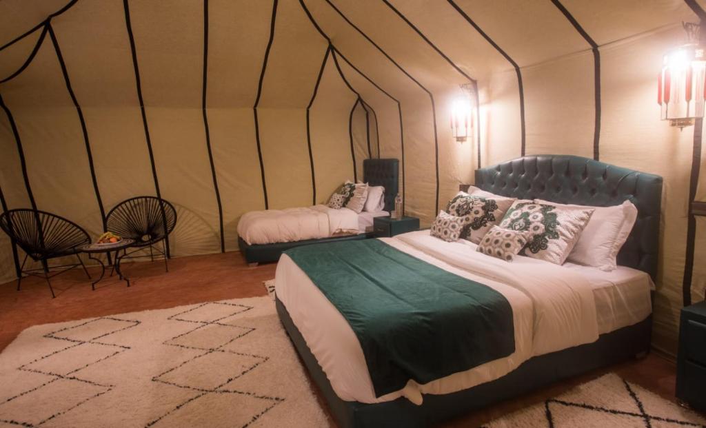 a bedroom with a bed in a tent at Luxury Desert Camp Amanar in Merzouga
