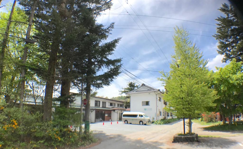 una furgoneta blanca estacionada frente a una casa en Ikoisanso, en Karuizawa
