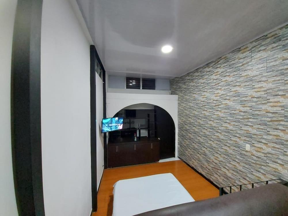 a living room with a brick wall and a couch at Apartaestudio2 Sector Cable-Estadio in Manizales