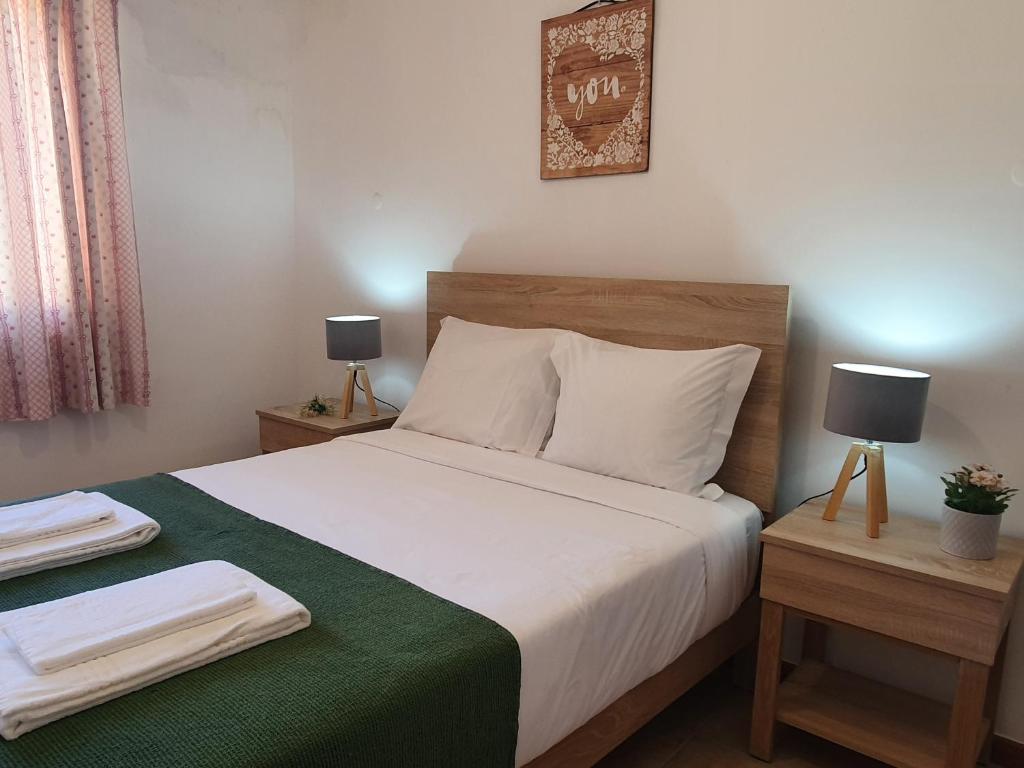 1 dormitorio con 1 cama grande con manta verde en Tróia Beach Villa, en Tróia