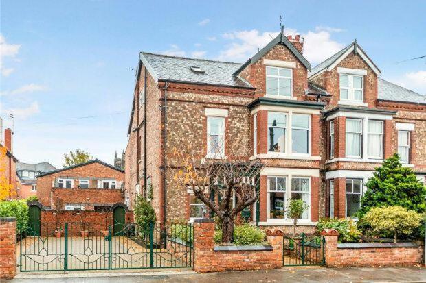 a brick house with a gate in front of it at Queens One in Urmston