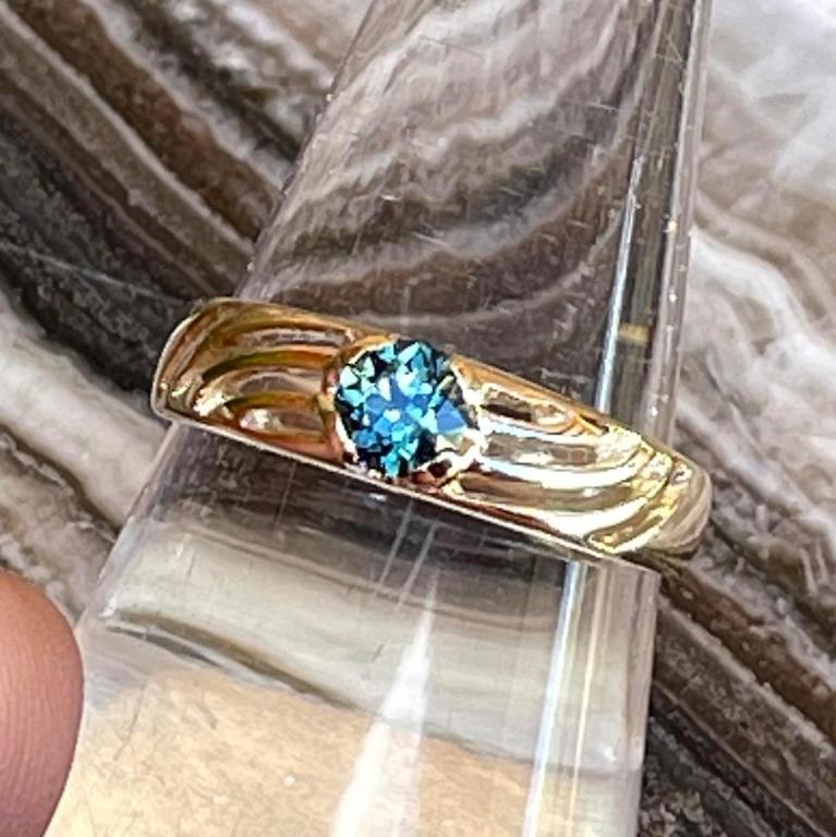 a gold ring with a blue topaz in it at Rubyvale Motel & Holiday Units - An Adults Only Getaway in Rubyvale