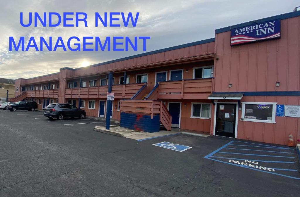 a building with a sign that reads under new management at American Inn - Grover beach - Pismo Beach in Grover Beach