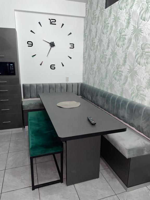 een tafel en stoel met een klok aan de muur bij Green Space in Tarija