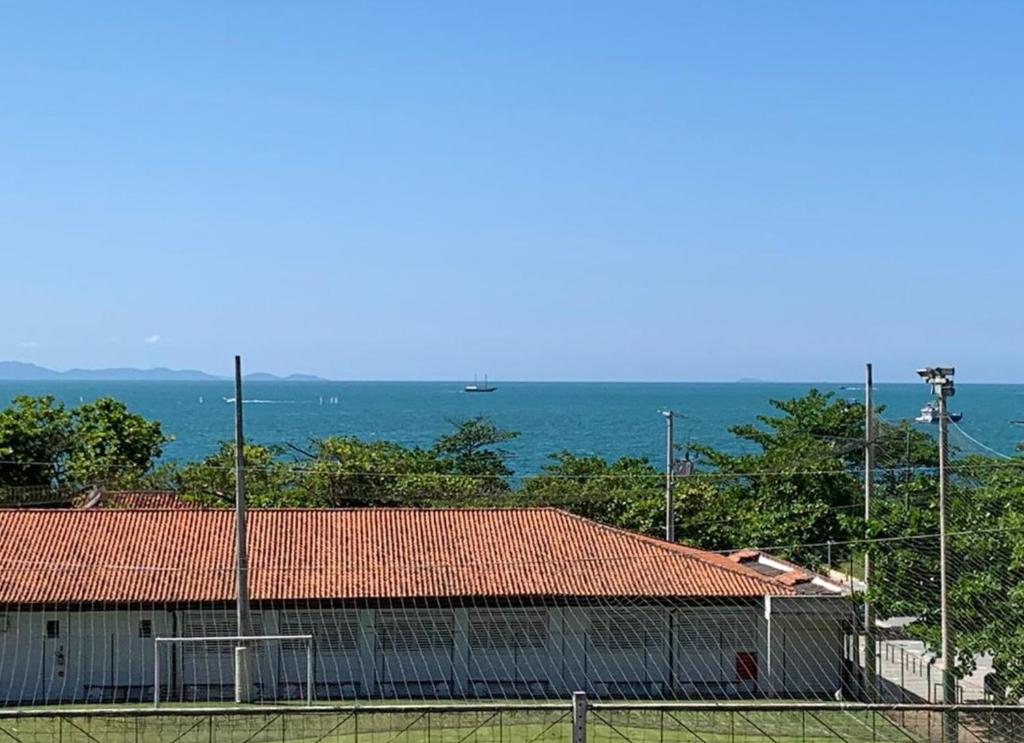 ein Gebäude mit einem Zaun vor dem Meer in der Unterkunft Ap novo com vista para o mar de Jurerê in Florianópolis