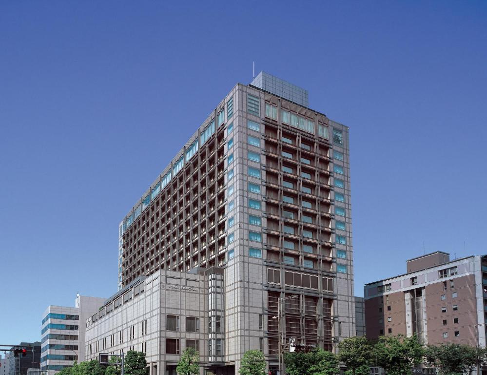 京都市にあるホテルオークラ京都の一部の建物の前の高いガラス張りの建物