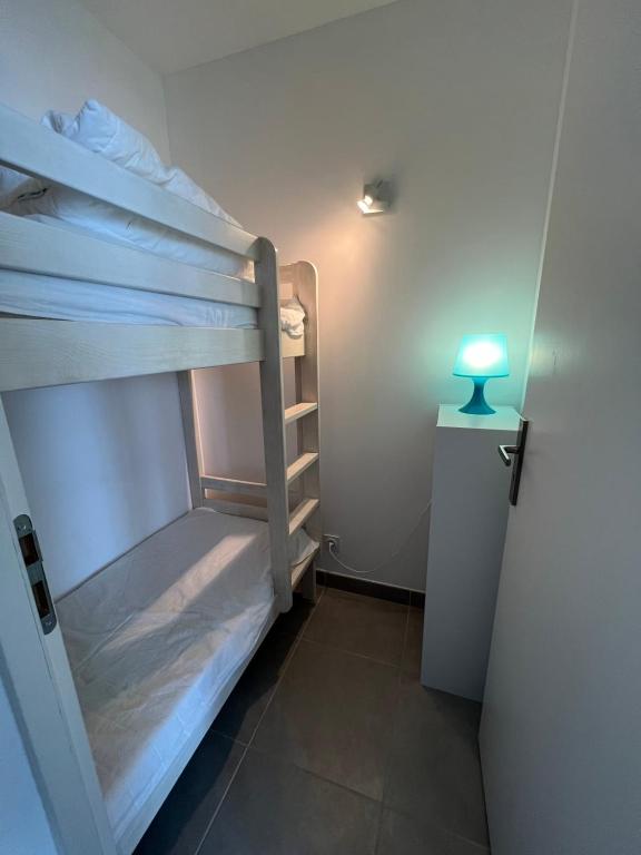 a room with two bunk beds next to a door at Les Pieds dans le Sable in Le Grau-du-Roi