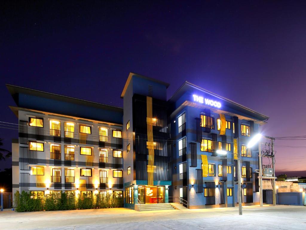 a hotel building with a lit up sign at night at The Wood Pattani Hotel in Ban Ru Sa Mi Lae