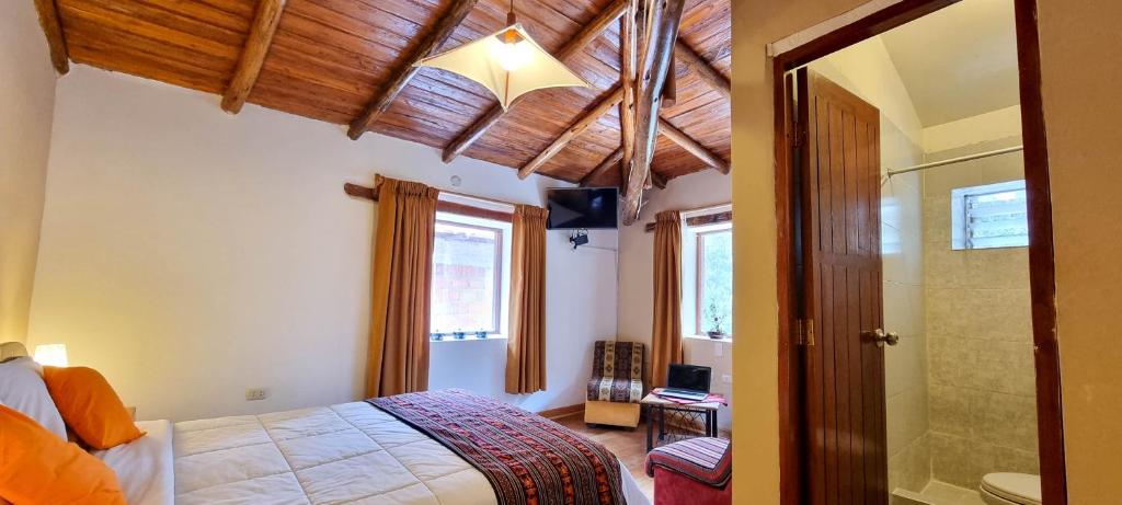 a bedroom with a bed and a walk in shower at Casa de Ollanta ByB in Ollantaytambo