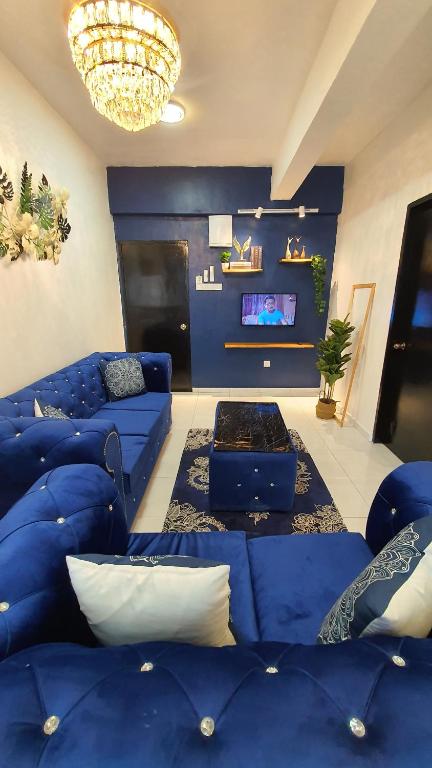 a living room with blue couches and a tv at D'MANGO COTTAGE MELAKA HOMESTAY BANDAR HILIR DAN KLEBANG in Malacca