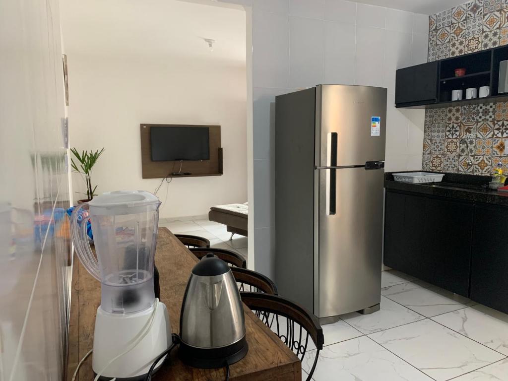 a kitchen with a refrigerator and a table with a blender at Apartamento para temporada HospedagemOuroPreto202 in Ouro Preto