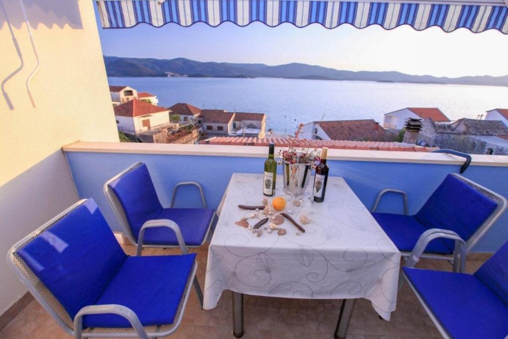 d'une table et de chaises sur un balcon avec vue sur l'eau. dans l'établissement Apartments Drago - with sea view, à Klek
