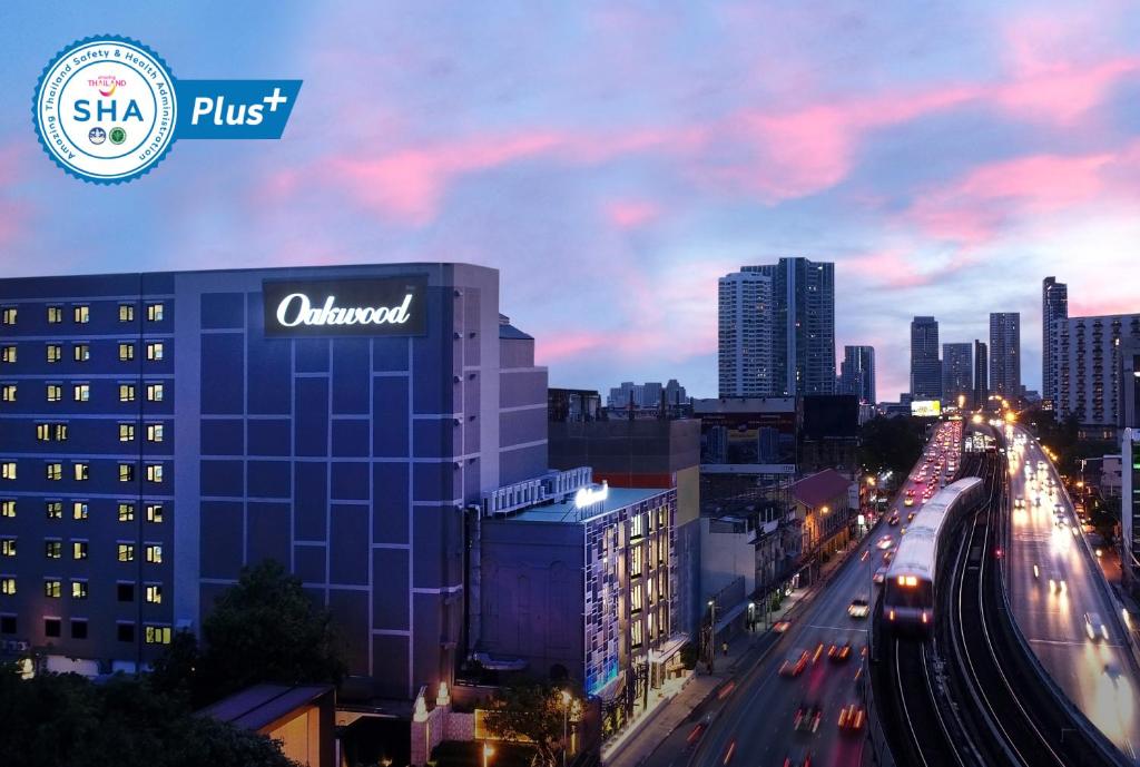een uitzicht op een stad 's nachts met auto's bij Oakwood Hotel & Residence Bangkok SHA Plus Certified in Bangkok