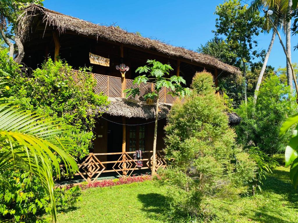 a resort building with a thatched roof at Sigiri Lion Eco Palace in Sigiriya