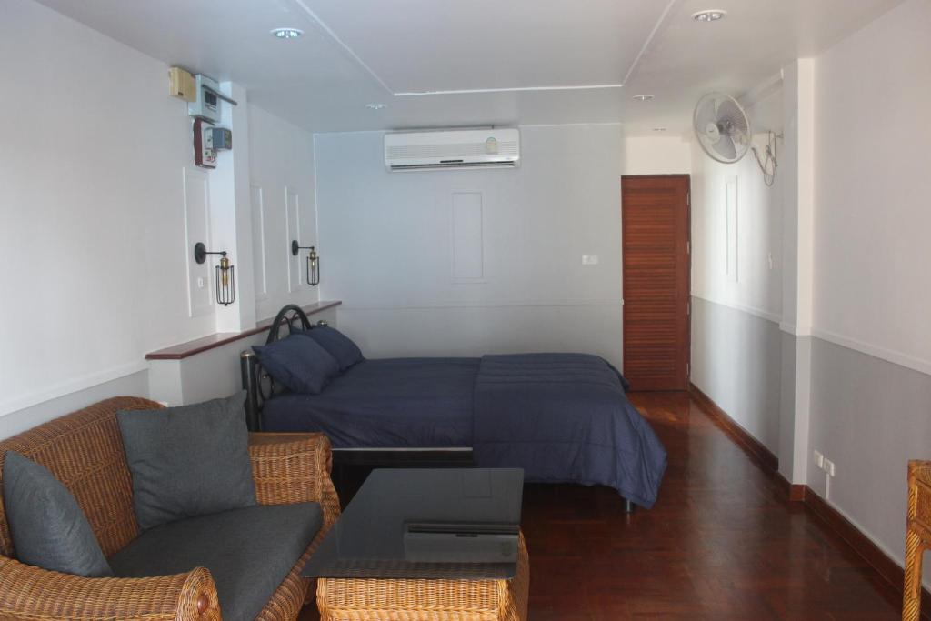 1 dormitorio pequeño con 1 cama y 1 sofá en Friends of Koh Samui 1, en Ban Lamai